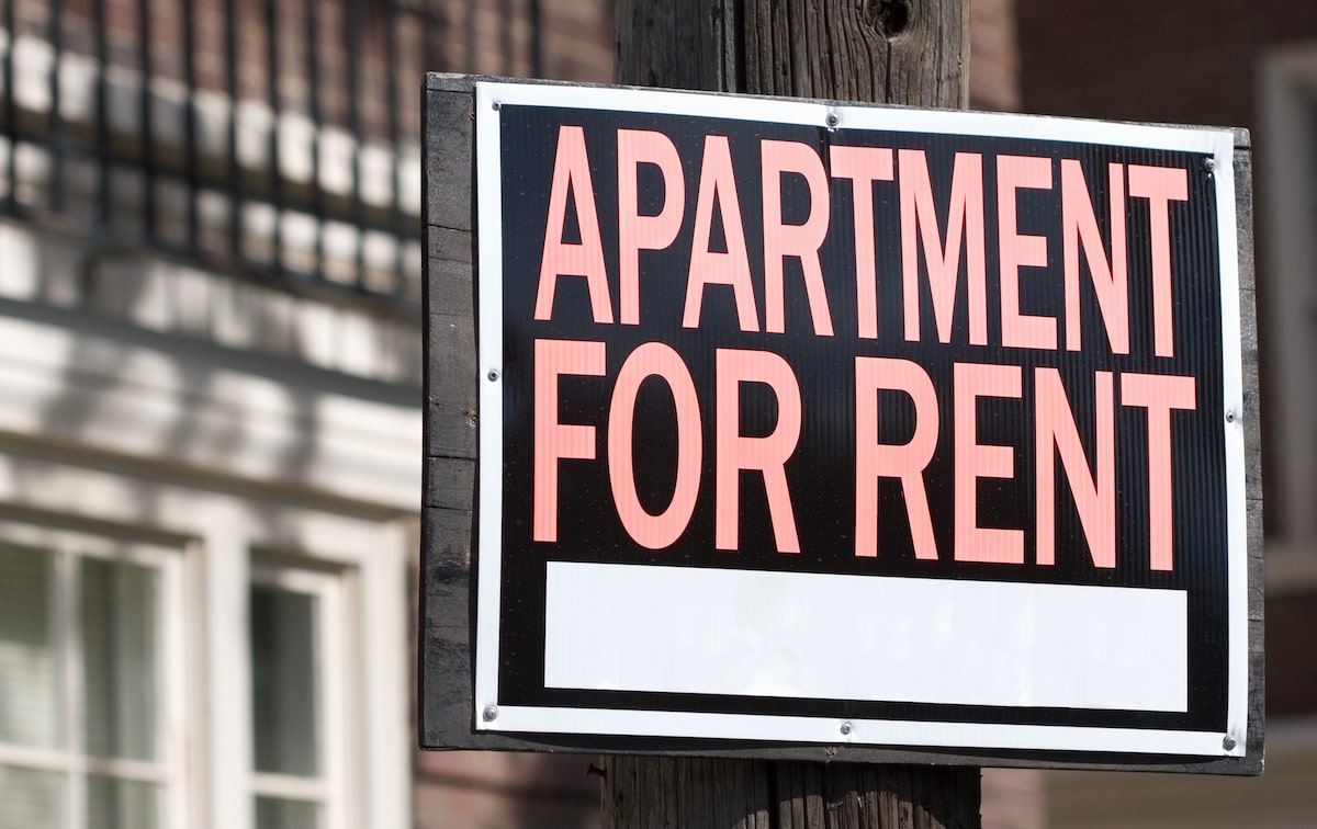 Orange and black 'apartment for rent' sign on light pole
