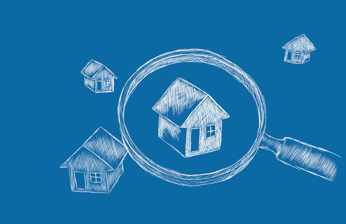 Blueprint of houses under magnifying glass with blue background