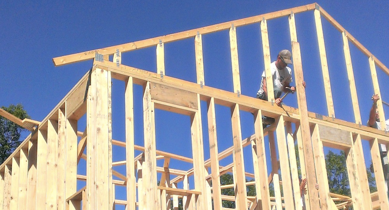 building crew framing a house using wood construction