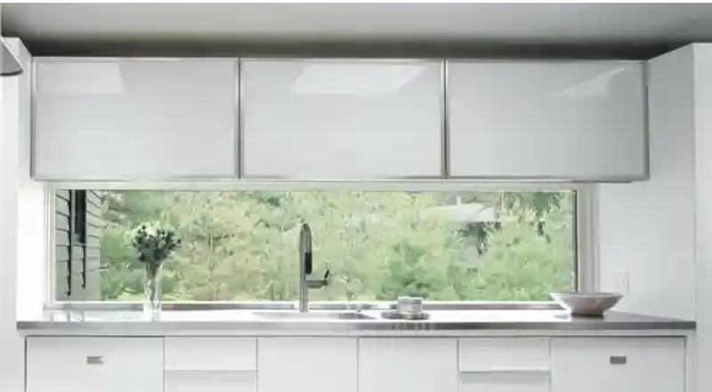 Strip of fixed-pane window over kitchen sink and under the kitchen cabinets