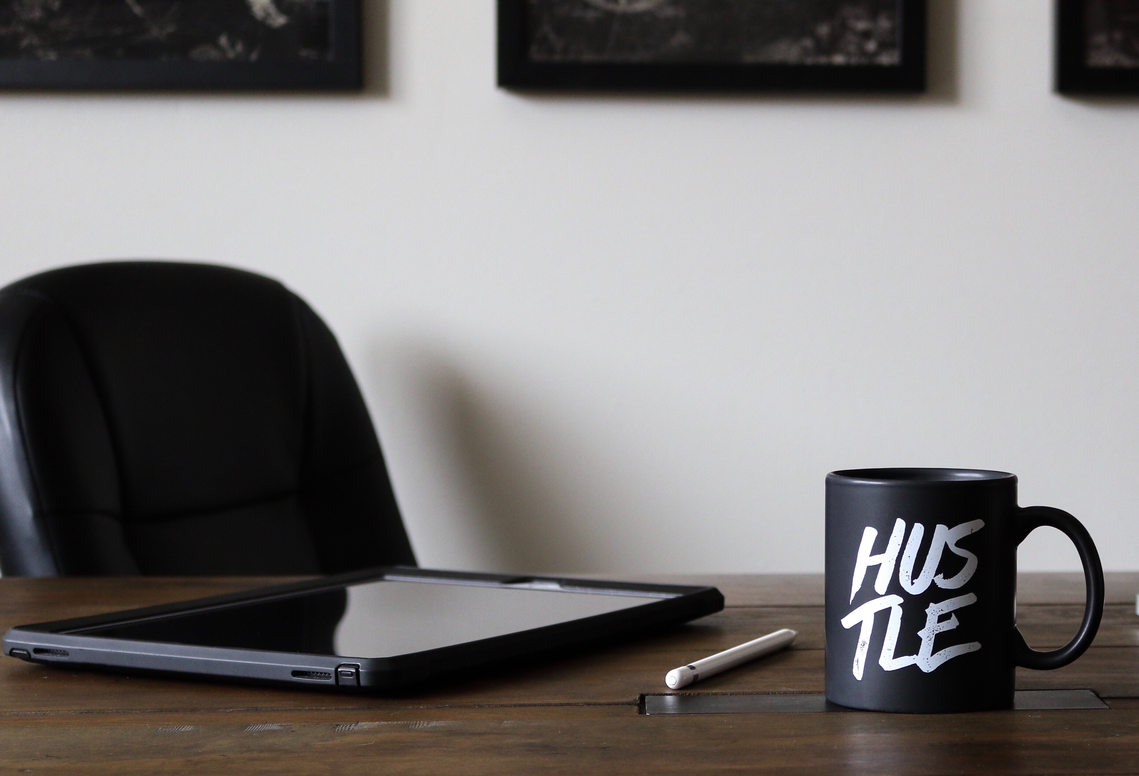 'Hustle' mug on desk with tablet