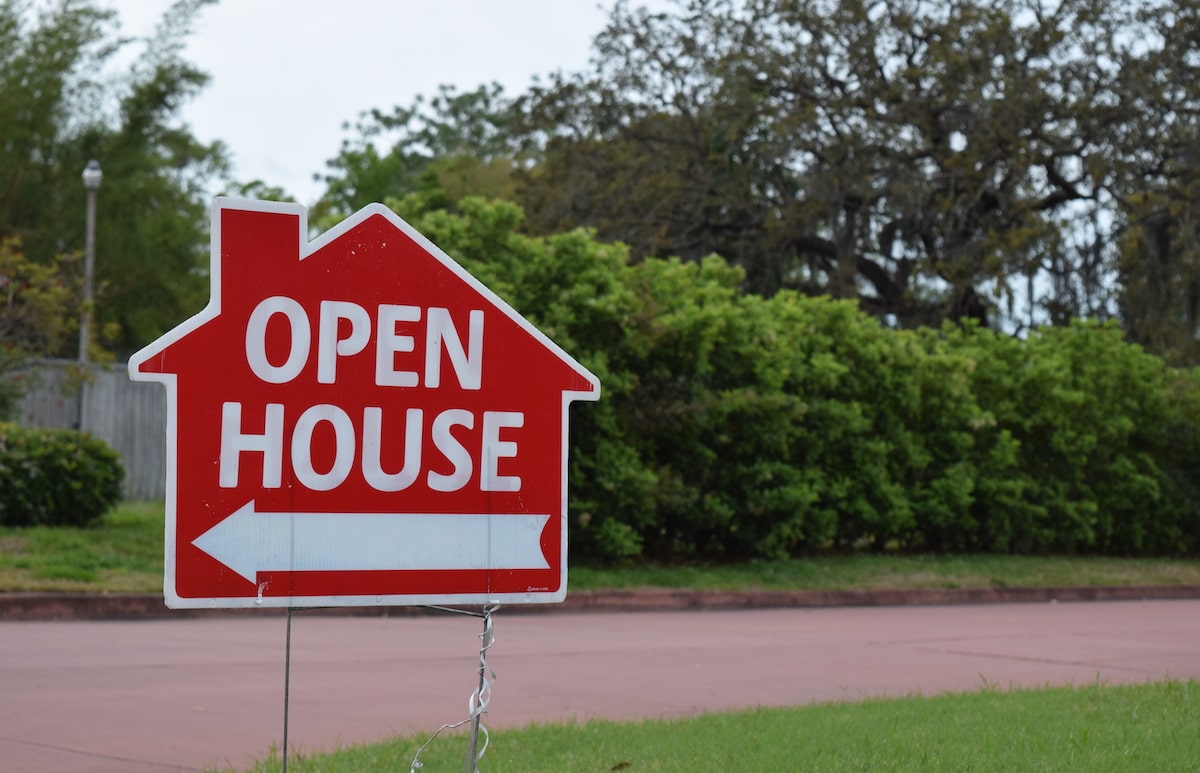 Red open house sign on lawn