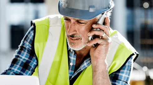 American Express image of construction worker on mobile device