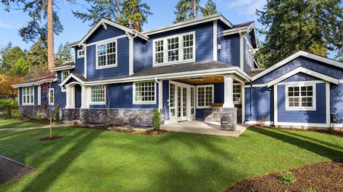 Large blue home with green grass