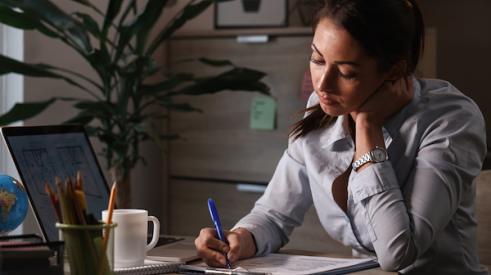 Woman sitting at desk filling out paperwork