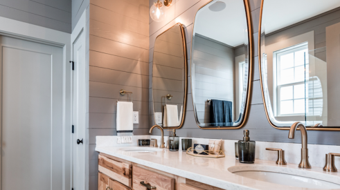 this master bath design from Garman Homes has accent tile and brass fixtures—two features homebuyers want today