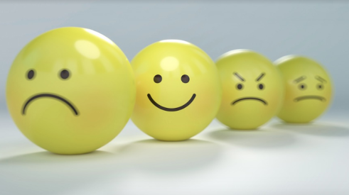 Happy and sad faces on yellow balls