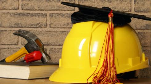 Hammer, books, hard hat and graduation cap