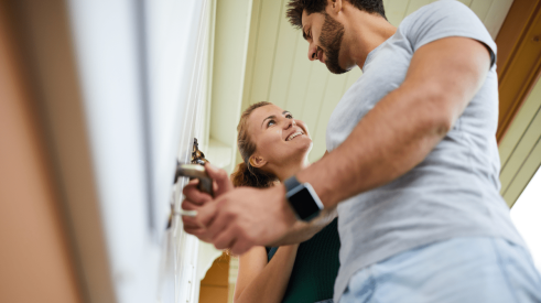 U.S. homeowner couple unlocking door of their new home