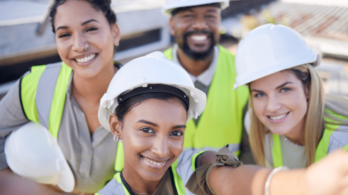Group of smiling construction workers includes women and minorities