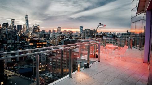 View of New York City at dusk from a penthouse balcony