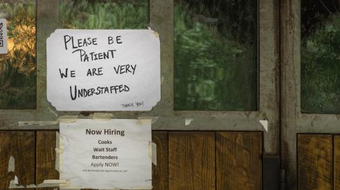 Help wanted sign posted in window of restaurant
