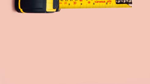 Tape measure on pink background