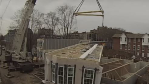 Crane lifting prefabricated apartment building modules into place