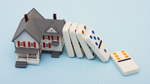 Dominoes falling on replica house