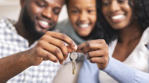 Family holding keys to their home