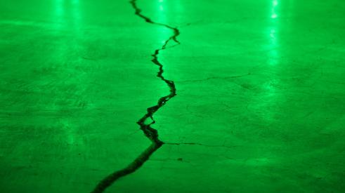 Crack in concrete with green light