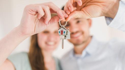Millennial homebuyers with house keys in hand
