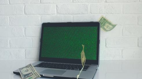 Laptop computer with dollar bills