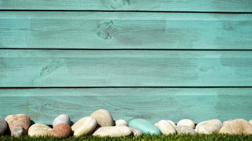 Blue siding with stones and grass