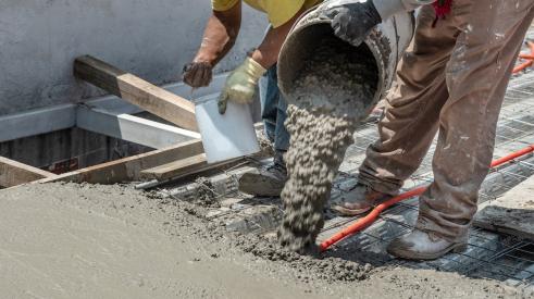 Builders pouring concrete on jobsite