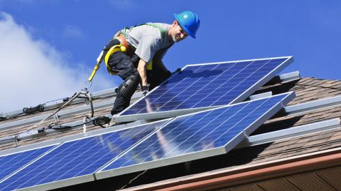 Man-on-roof-installing-solar-panels
