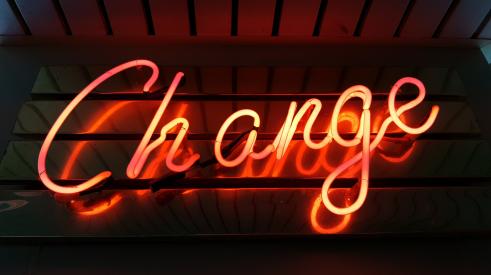 red and orange neon sign saying 'change'