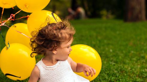 Little girl with yellow balloons