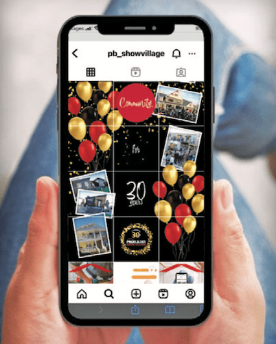 Hands holding smartphone with PB Show Village Instagram on screen