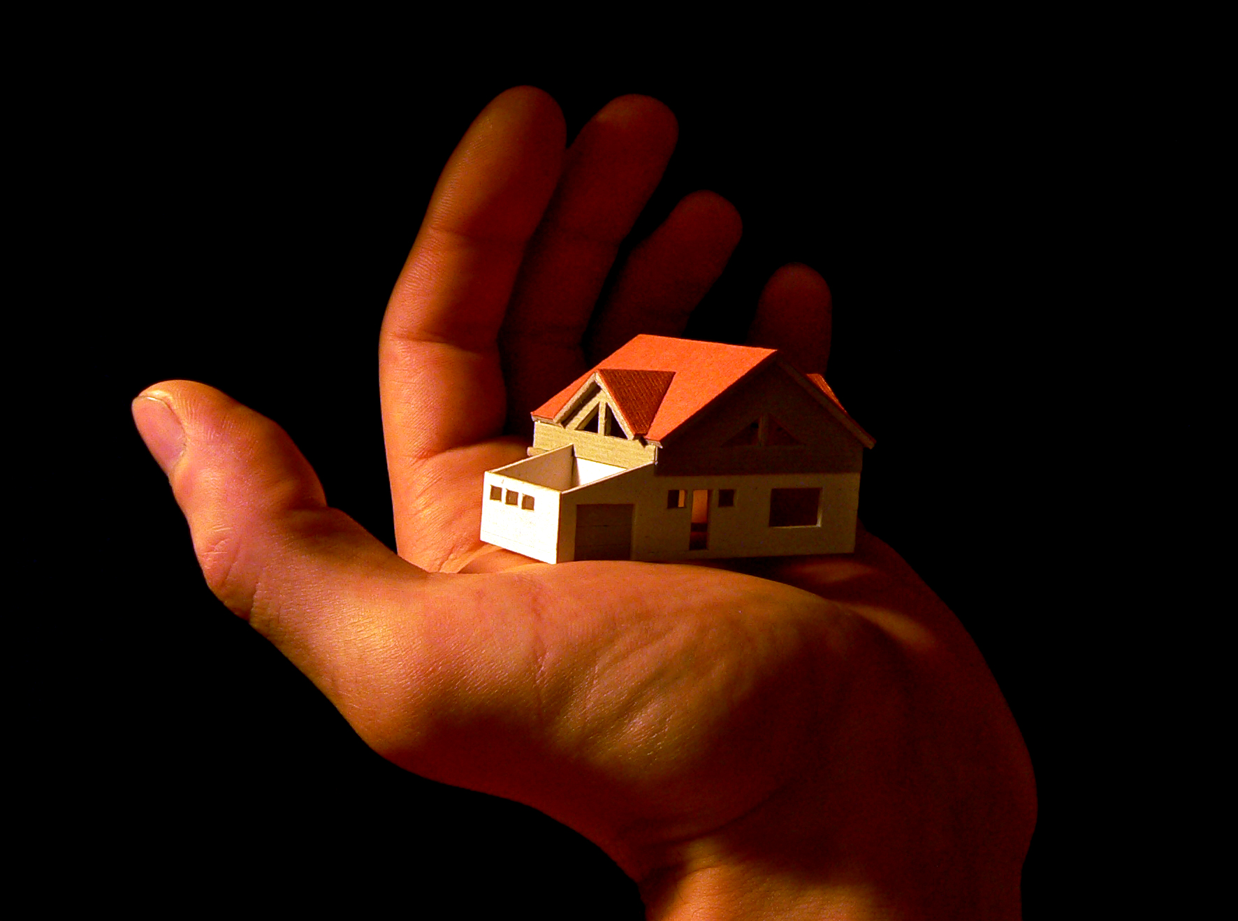 House model in the palm of a man's hand