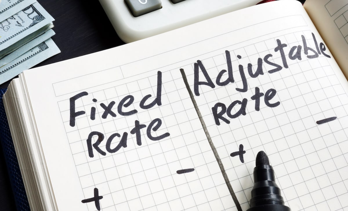 Person writing pros and cons of fixed interest rate and adjustable rate