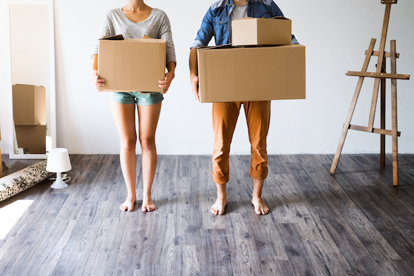 A couple holding moving boxes