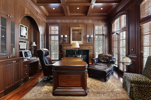 Wood-paneled home office with leather chairs and heavy wood desk