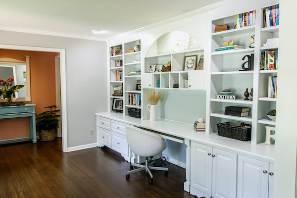 Home office with bookshelves spanning the wall
