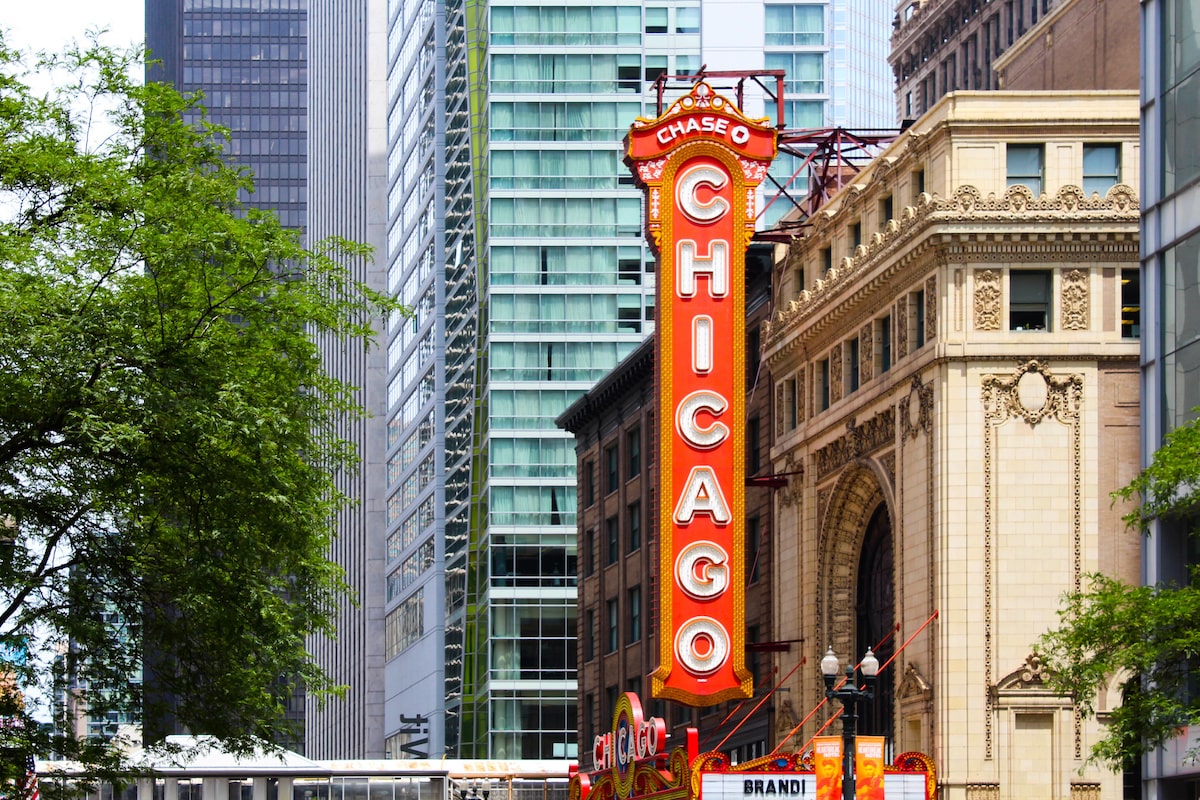 A Chicago sign is in front of several skyscrapers.