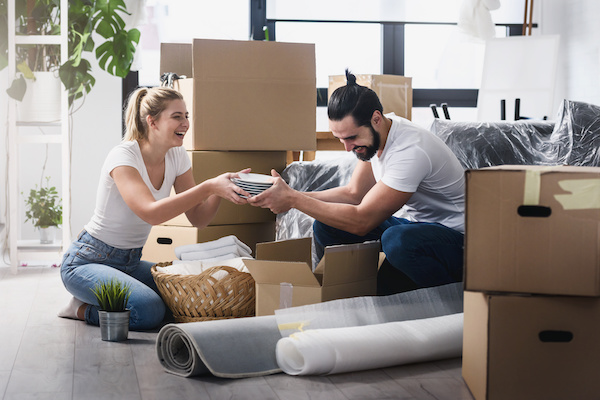 Couple laughing as they pack moving boxes