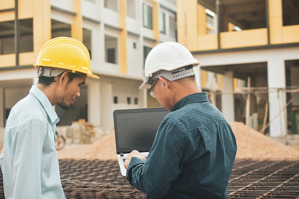 Two construction workers using a laptop 