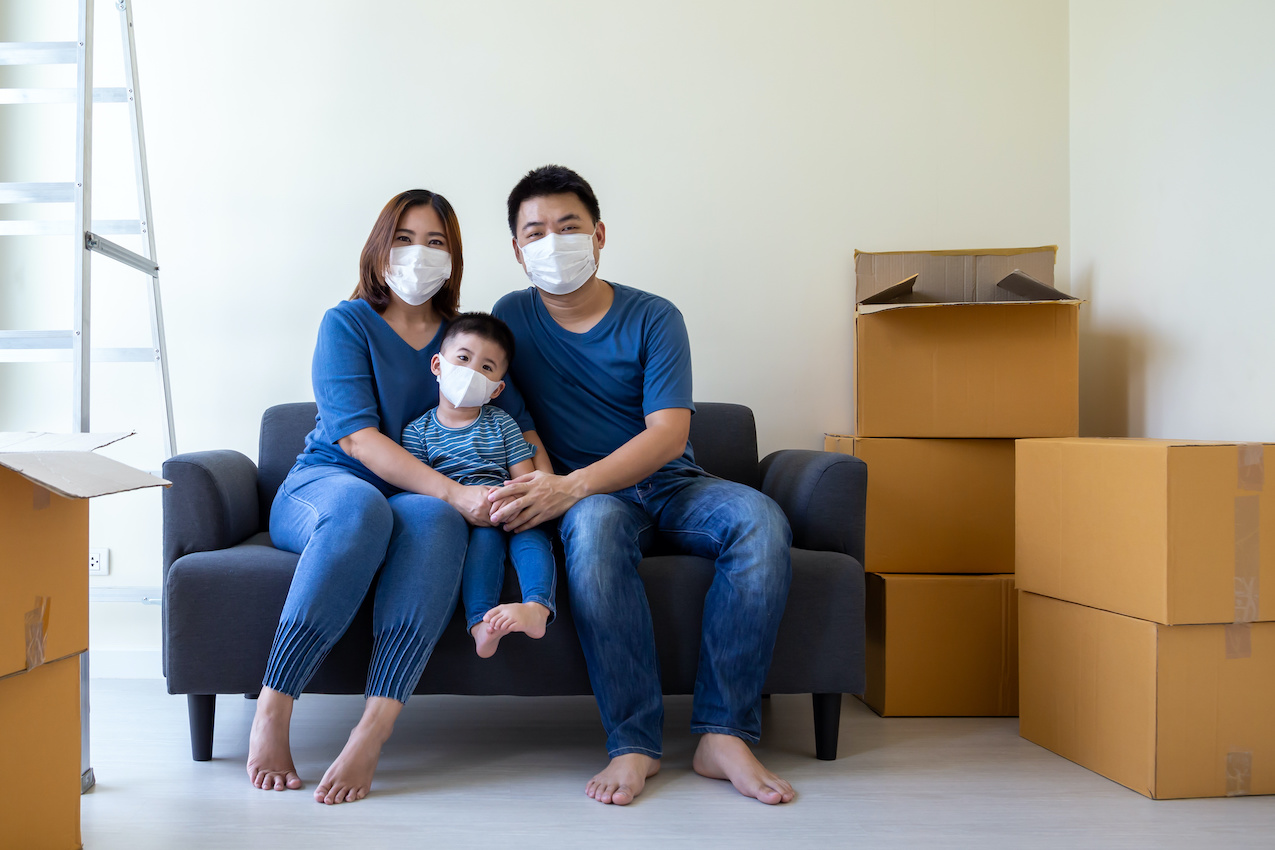 Family with masks and moving boxes