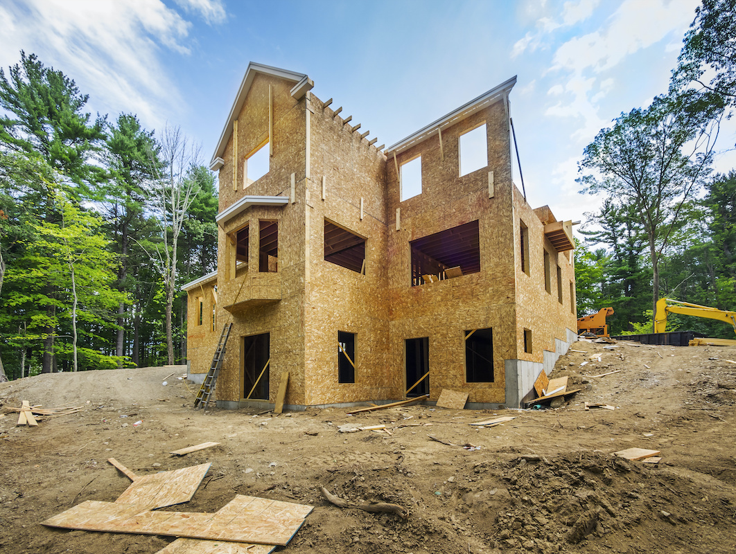 Single-family home construction site with framing almost complete