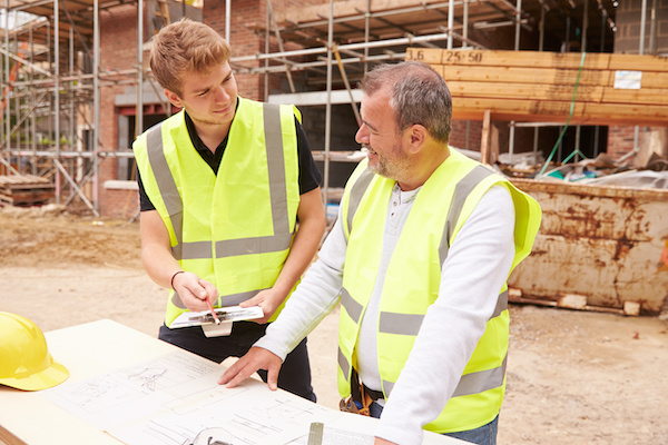 Home builder talking to apprentice