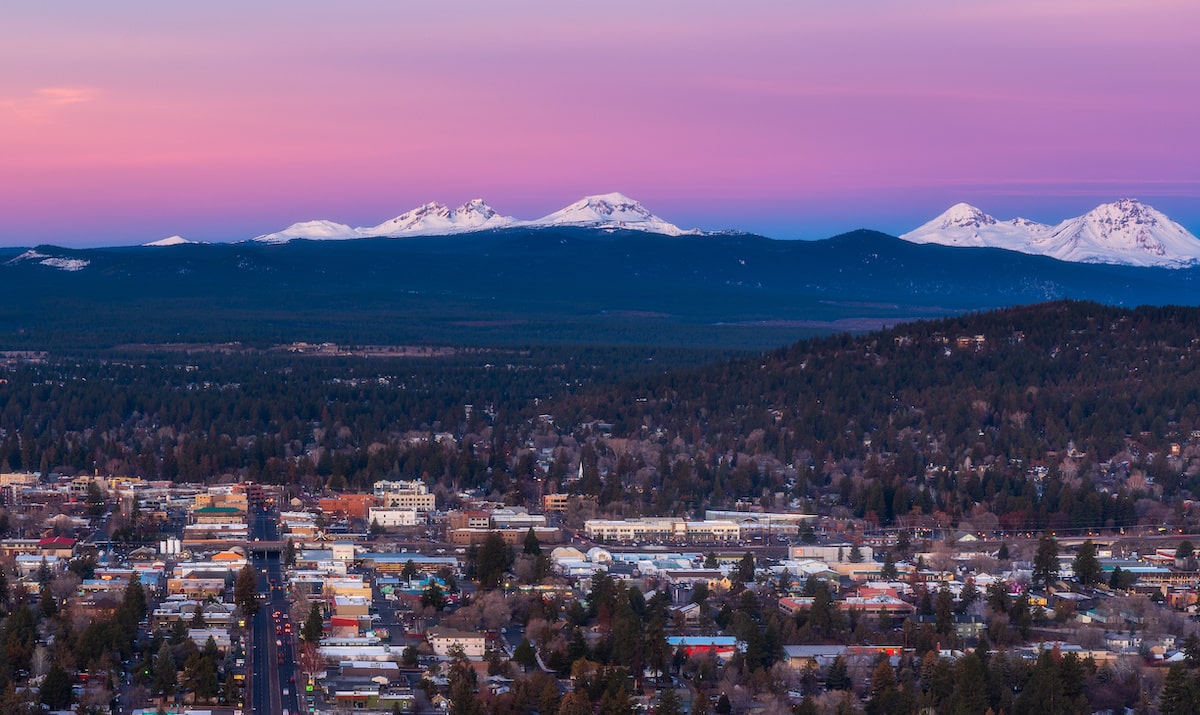 Bend, Oregon backdropped by Cascade mountains at sunset