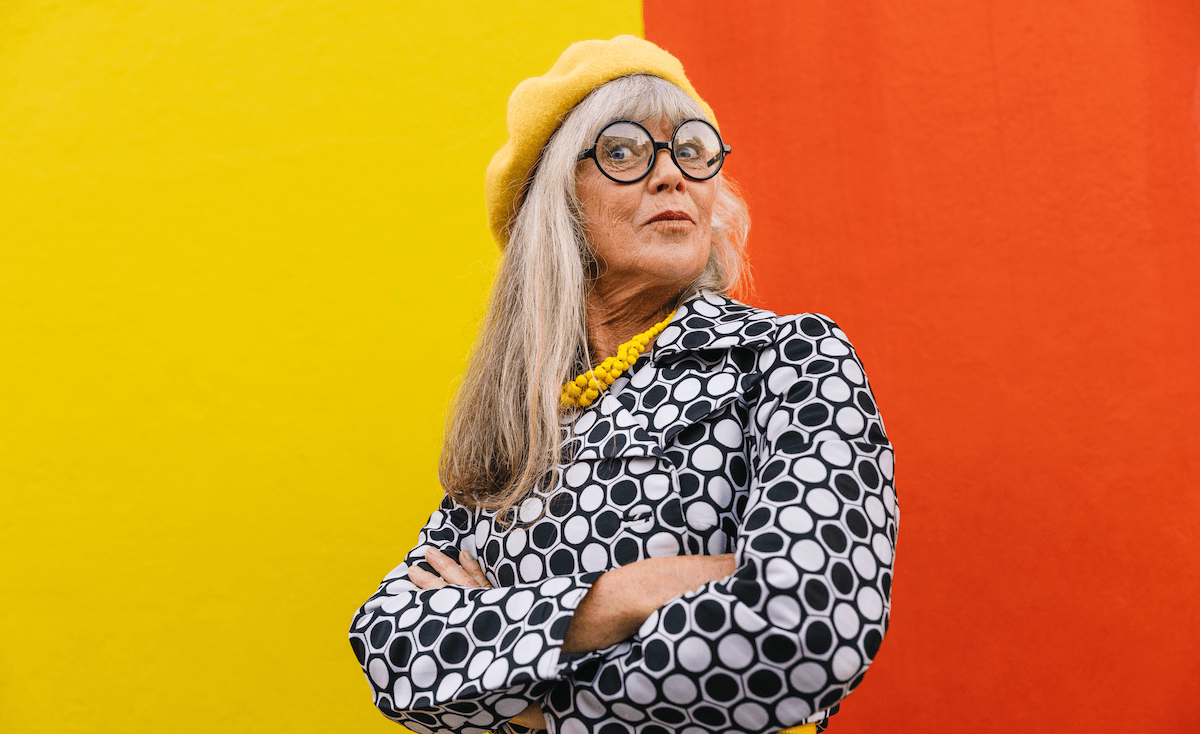 Baby Boomer woman with attitude against a red and yellow backgound