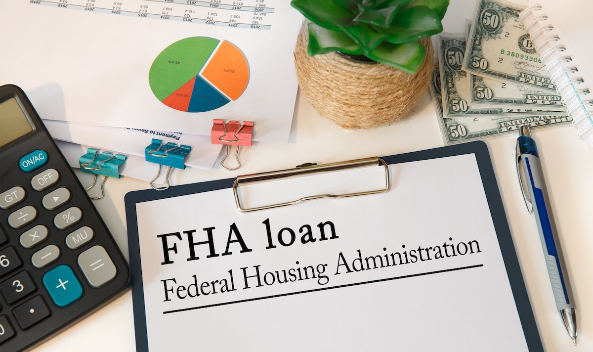 FHA loan paperwork on desk with calculator and statistics 
