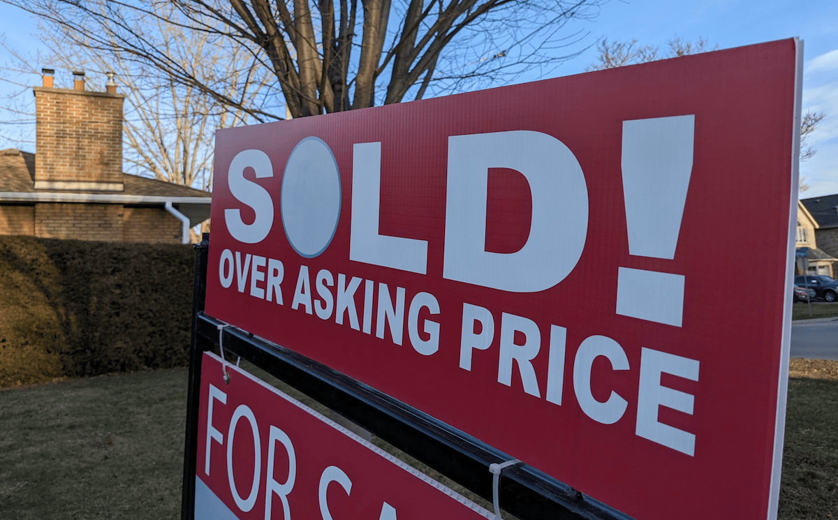 In a hot housing market, this red and white sign says home sold above asking price