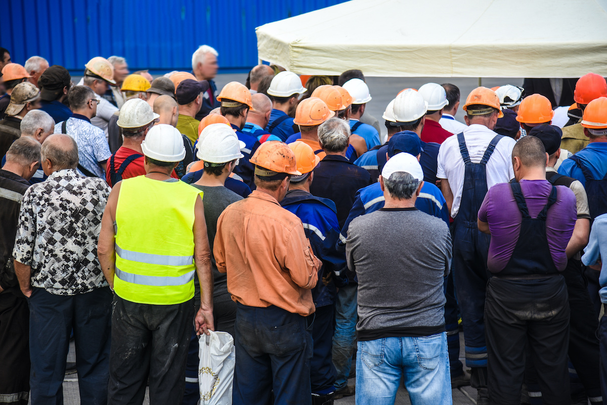 Crowd of construction workers wearing hard hats