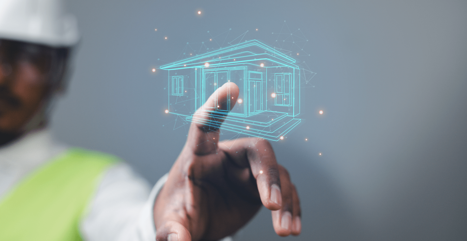 Man's hand reaching toward building information modeling home floating in air