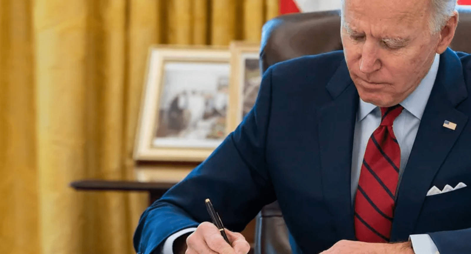 President Biden at desk signing legislation