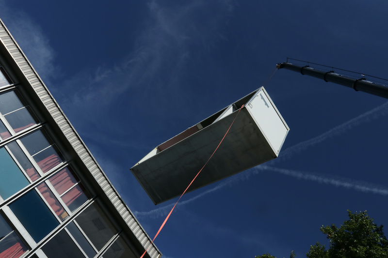 sectioin of modular home hoisted by a crane
