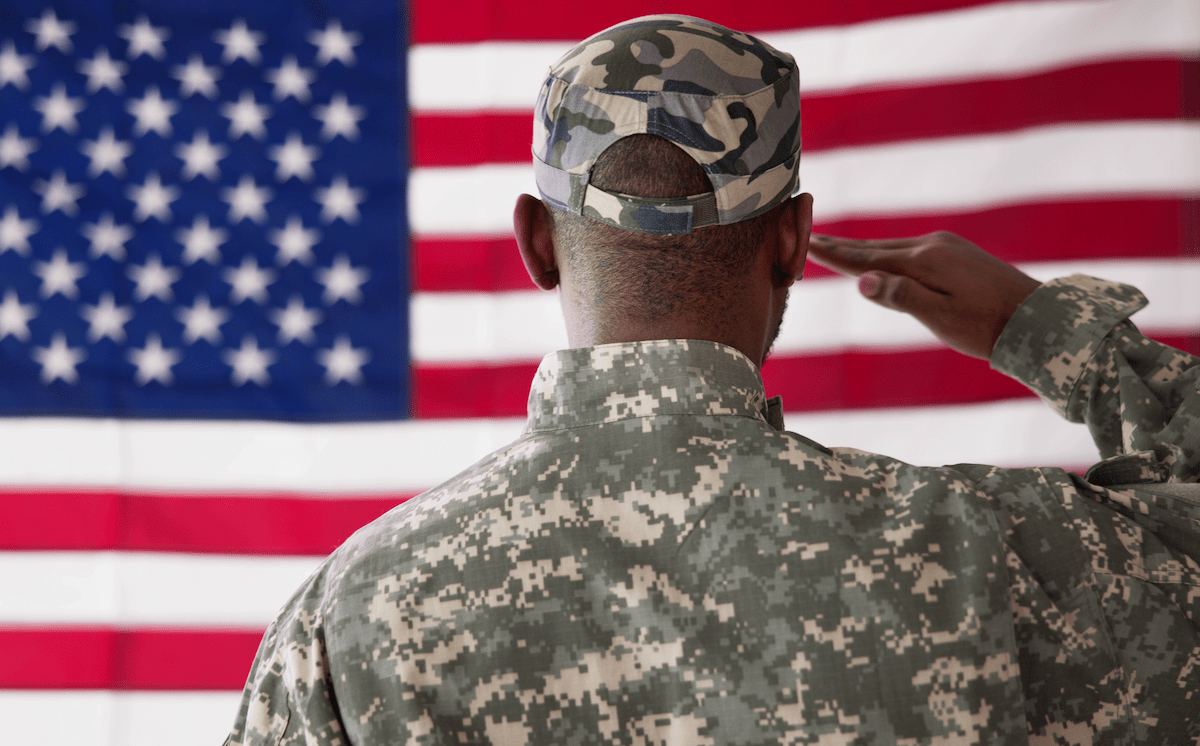 Member of U.S. military salutes American flag