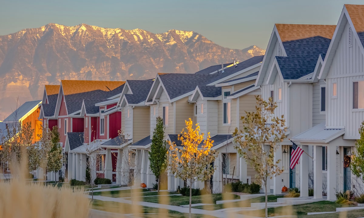 Colorful Utah homes in a row backdropped by mountain range